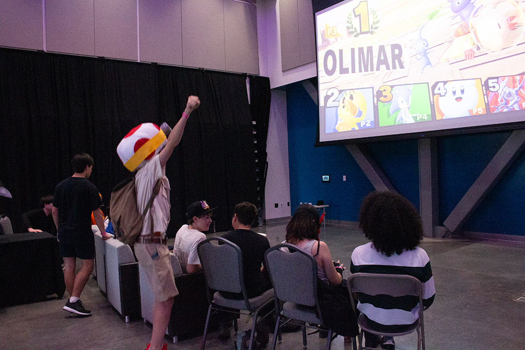Attendees play smash bros, captain toad shouts victoriously
