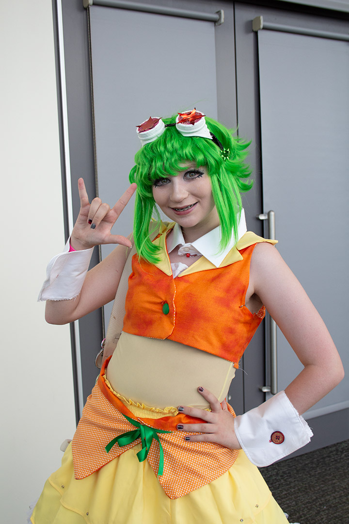 A cosplayer in bright colors and goggles