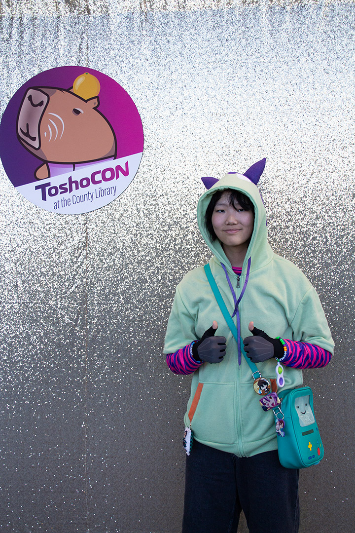 A cosplayer posing in front of a backdrop